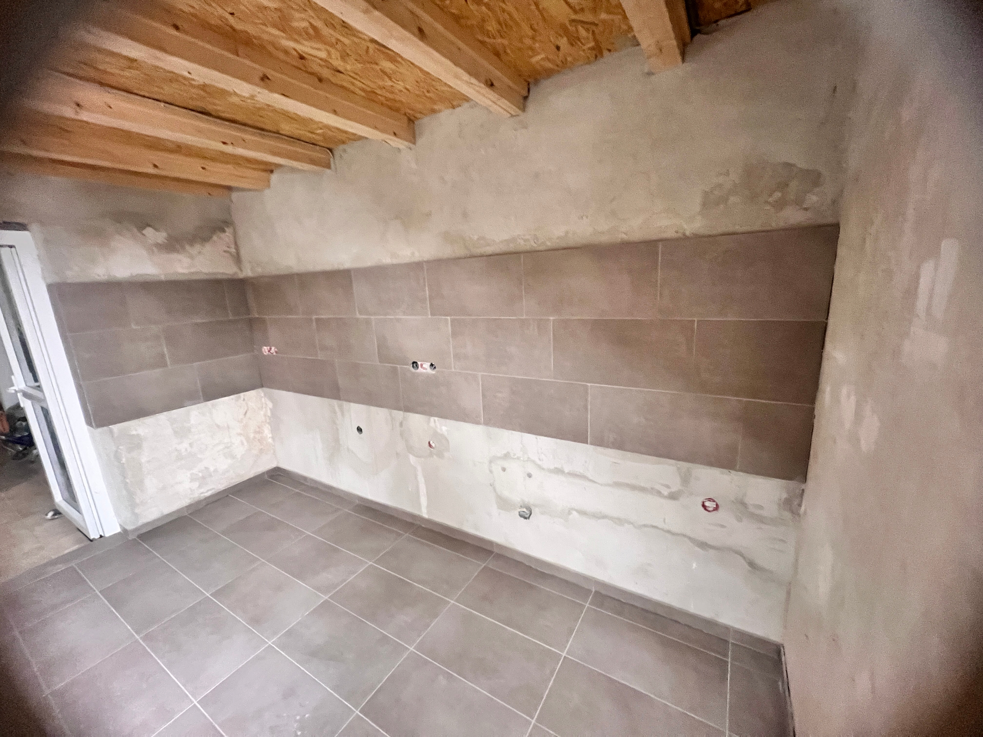 Küchenwand mit neu verlegtem Fliesenspiegel und Bodenfliesen