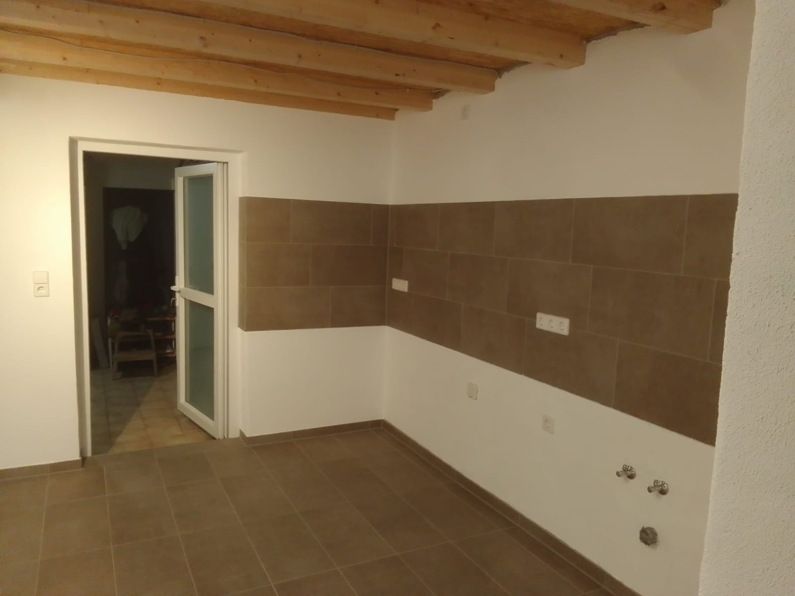 Raum mit teilweisen Wandfliesen und Holzdecke